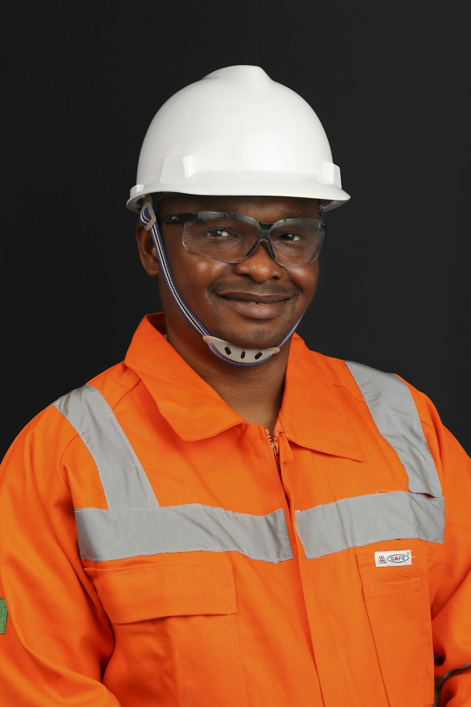 Smiling engineer wearing a hard hat and safety glasses