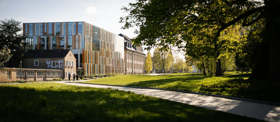 Modern campus building beside a green lawn
