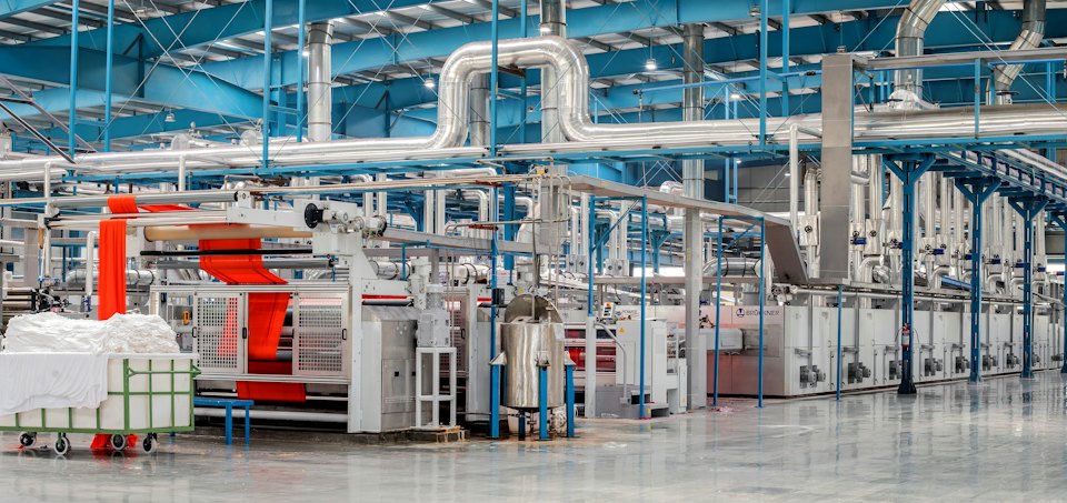Factory floor with production machinery and overhead pipework