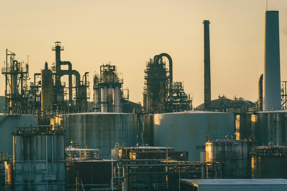Oil refinery towers and pipework at golden hour
