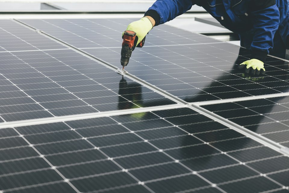Technician installing rooftop solar panels