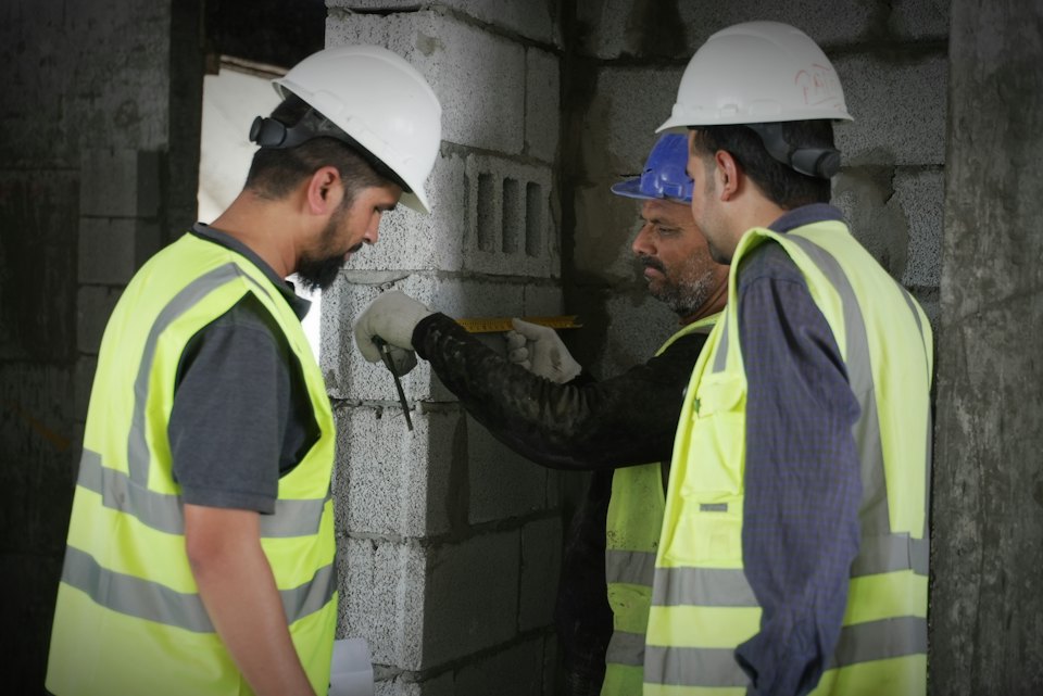 Engineers in hard hats and high-visibility vests reviewing work on site